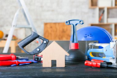 Ahşap masa üzerinde müteahhit malzemesi olan bir ev.