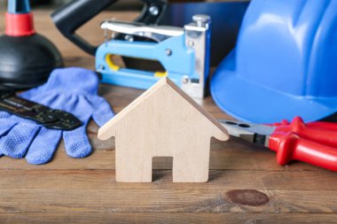 Ahşap masa üzerinde inşaat malzemeleri olan bir ev, yakın plan.