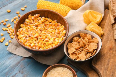 Farklı tahıllar ve ahşap arka planda çiğ makarna, yakın plan.