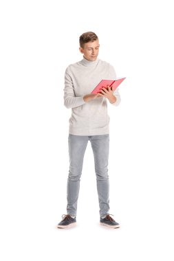 Genç adam beyaz arka planda kırmızı kitap okuyor.