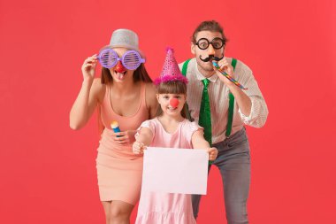 Komik kılık değiştirmiş genç bir aile ve renkli arka planda boş kağıt kağıtları var. 1 Nisan şakası