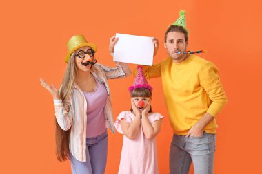 Komik kılık değiştirmiş genç bir aile ve renkli arka planda boş kağıt kağıtları var. 1 Nisan şakası