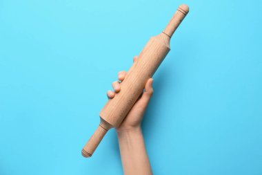 Renk arkaplanında oklavası olan kadın el