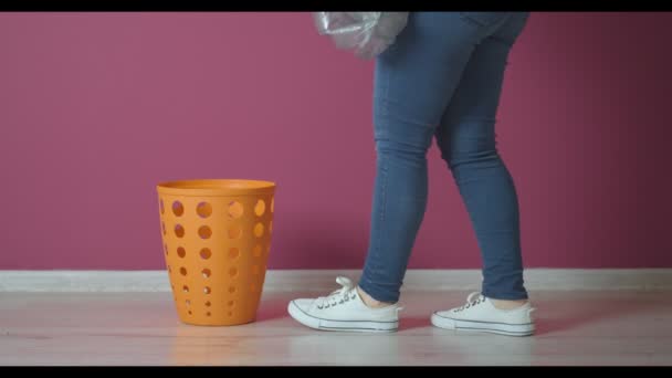 新しいゴミ袋をカラーウォールの近くのバケツに入れる女 — ストック動画