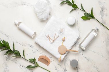 Bebek için banyo aksesuarları ve arka planda yeşil dallar.