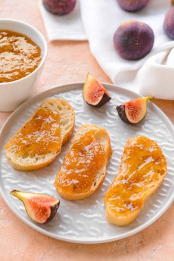 Toasts with sweet fig jam on color background