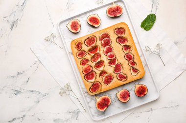 Tray with delicious fig pie on grunge background
