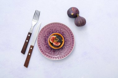 Tartlet with tasty chocolate and figs on light background