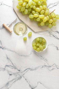 Glass of tasty white wine on white background