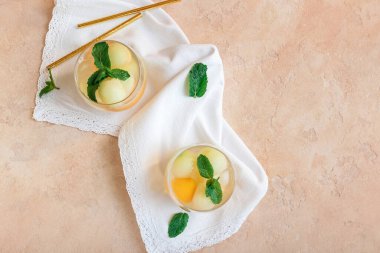Glasses of cold melon cocktail on color background