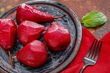 Plate of tasty poached pears in wine sauce on grunge background