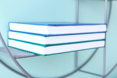Stack of books on shelf against color wall