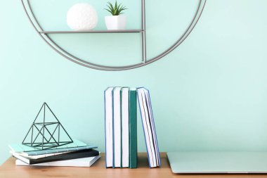 Stylish workplace with modern laptop against color wall in room