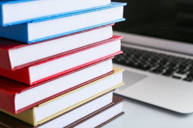 Masada yığınla kitap ve laptop var.