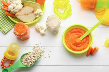 Composition with healthy baby food on light wooden background