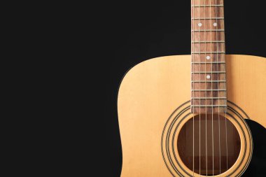 Acoustic guitar on dark background, closeup