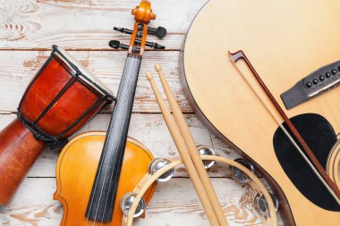 Different musical instruments on light wooden background, closeup
