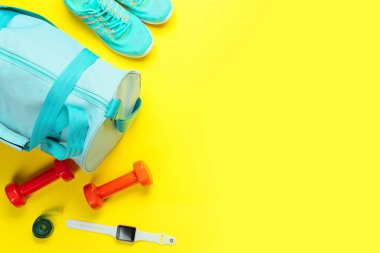 Renkli arka planda çanta ve spor ekipmanlarıyla kompozisyon