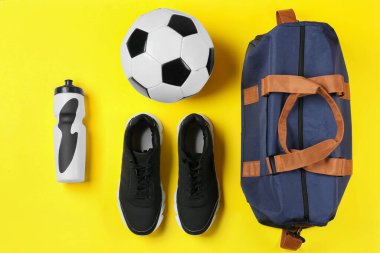 Renkli arka planda çanta ve spor ekipmanlarıyla kompozisyon