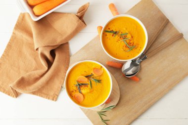 Beyaz arka planda havuç kremalı çorba.