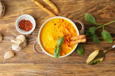 Ahşap zemin üzerinde taze havuç kremalı çorba pişiriyorum.