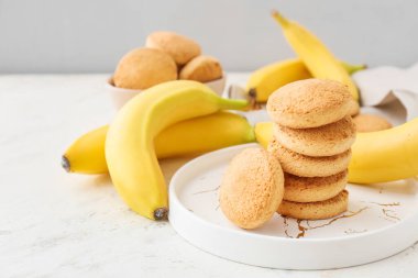 Lezzetli kurabiyeler ve hafif arka planda muzlu tabaklar.