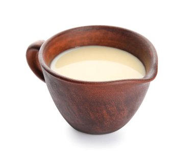 Beyaz arka planda tatlı yoğunlaştırılmış sütle sos teknesi.