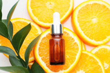 Beyaz arka planda turuncu bir yağ şişesiyle kompozisyon