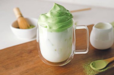 Bir fincan lezzetli dalgona matcha latte, masada, yakın plan.