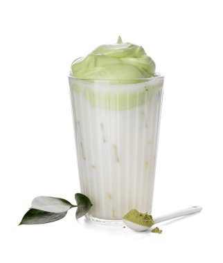 Bir bardak lezzetli dalgona matcha latte ve beyaz arka planda pudra ile kaşık