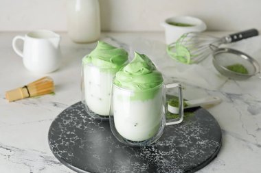 Hafif arkaplanlı lezzetli dalgona matcha latte tabakları