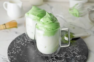 Hafif arkaplanlı lezzetli dalgona matcha latte tabakları