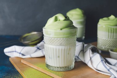 Koyu arkaplanda lezzetli dalgona matcha latte, yakın plan.