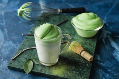 Renkli arkaplanda lezzetli dalgona matcha latte ile kompozisyon