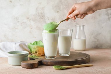 Masada lezzetli dalgona matcha latte hazırlayan kadın.