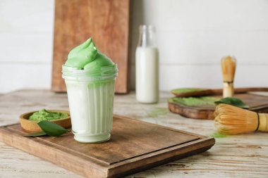 Ahşap arka planda lezzetli dalgona matcha latte ile kompozisyon