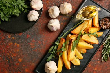 Arkaplanda sarımsaklı lezzetli fırında patates tabağı.