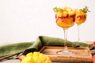 Hafif arka planda tropikal meyve salatası olan cam kaseler.