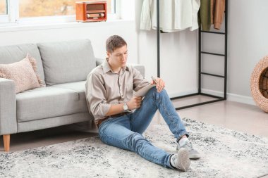 Handsome young man writing something at home