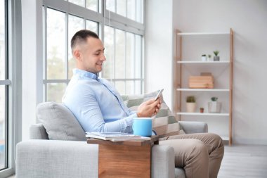 Evde cep telefonu olan yakışıklı bir genç.