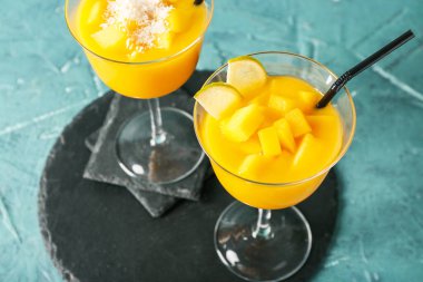 Renkli arkaplanda bir bardak mango margarita.