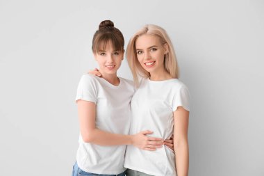 Gri arka planda genç lezbiyen çift