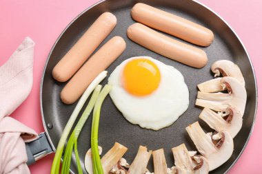 Renkli yumurta, sosis, mantar ve soğanlı kızartma tavası.