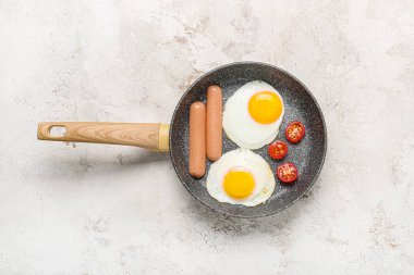 Hafif arka planda lezzetli yumurtalı tava, sosis ve domatesler.