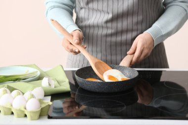 Kadın mutfakta yumurta pişiriyor.