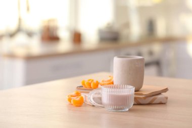 Aroma mumları, defter ve mandalina meyveleriyle mutfaktaki masada.