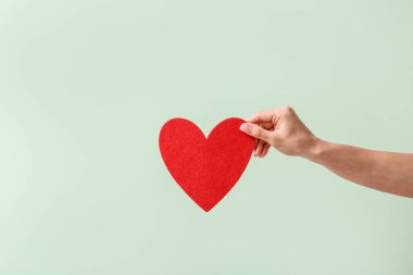 Renkli arka planda kırmızı kalpli el