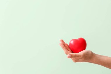 Renkli arka planda kırmızı kalpli el