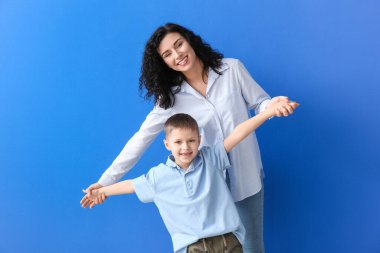 Mutlu kadın ve küçük oğlu renkli arka planda