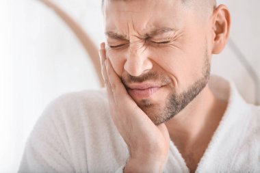 Sabahları diş ağrısı çeken bir adam.